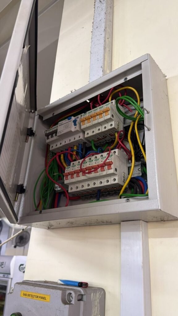 Newly wired distribution board with colour-coded cables and circuit breakers in a Singapore flat