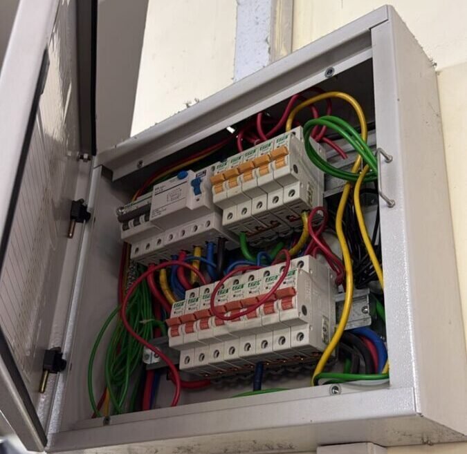 Newly wired distribution board with colour-coded cables and circuit breakers in a Singapore flat