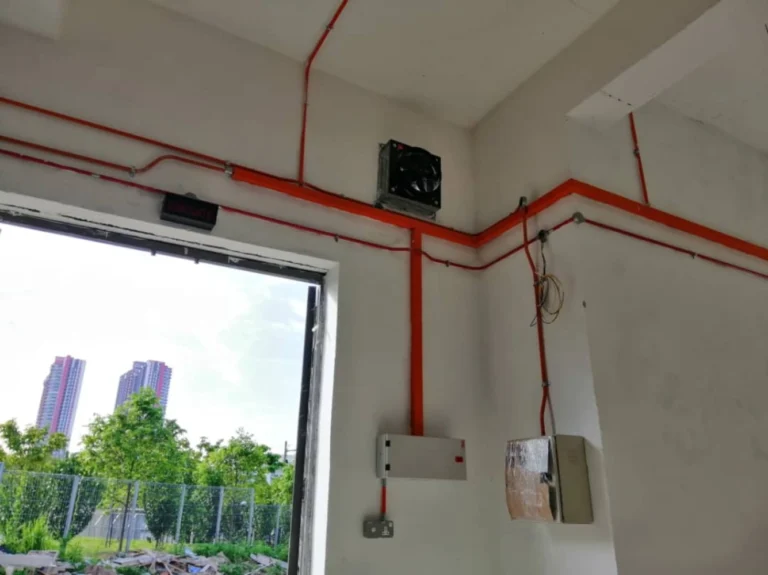 Exposed conduit wiring routed along wall and ceiling in a Singapore commercial space