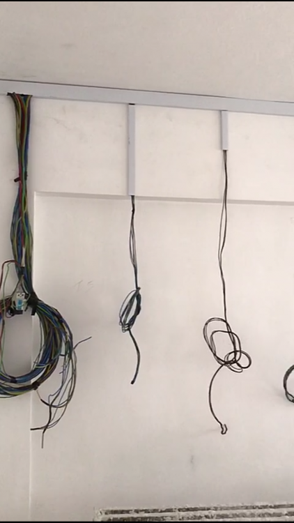 Cables run down the wall for switch and power point installation during rewiring in Singapore
