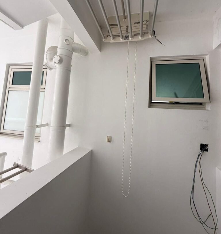 Service yard ceiling with pipes and wiring points for water heater installation in a Singapore HDB flat
