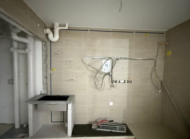Kitchen wall with pipes and new wiring points for water heater and appliances in Singapore