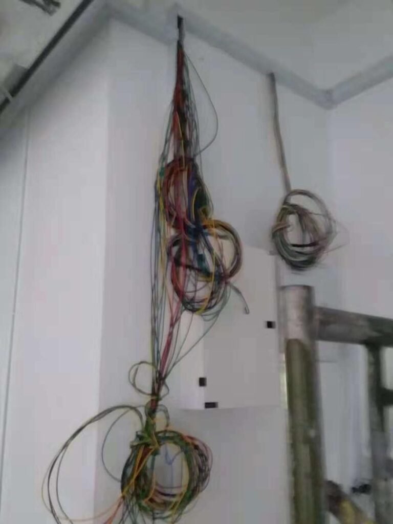 Bundle of old tangled electrical wires exposed during rewiring of an HDB flat in Singapore