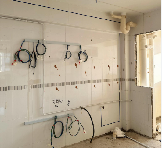 Kitchen wall with coiled cables ready for power point installation in a Singapore HDB kitchen