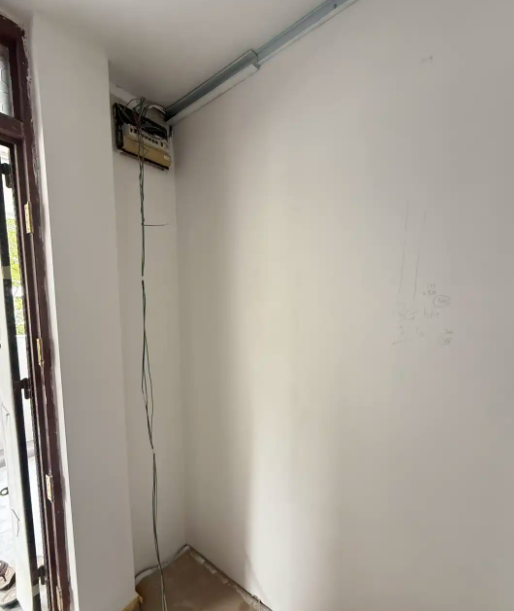 New cable dropped from a ceiling junction box to a wall switch point during rewiring in Singapore