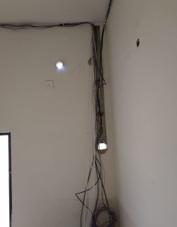 Cable bundle run to a ceiling downlight point during lighting installation in Singapore